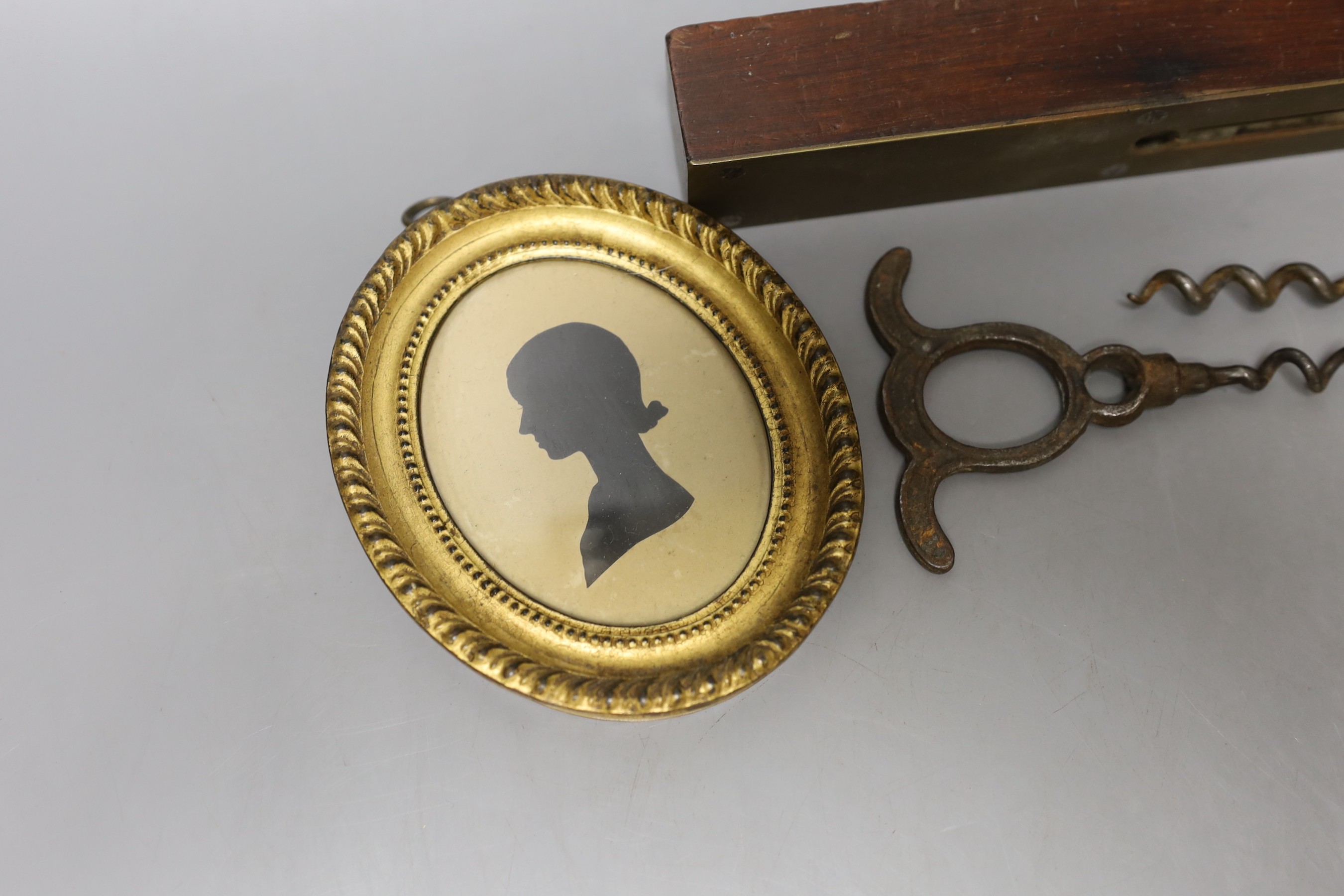 A George III framed silhouette, two corkscrews, spirit level and circular miniature painting